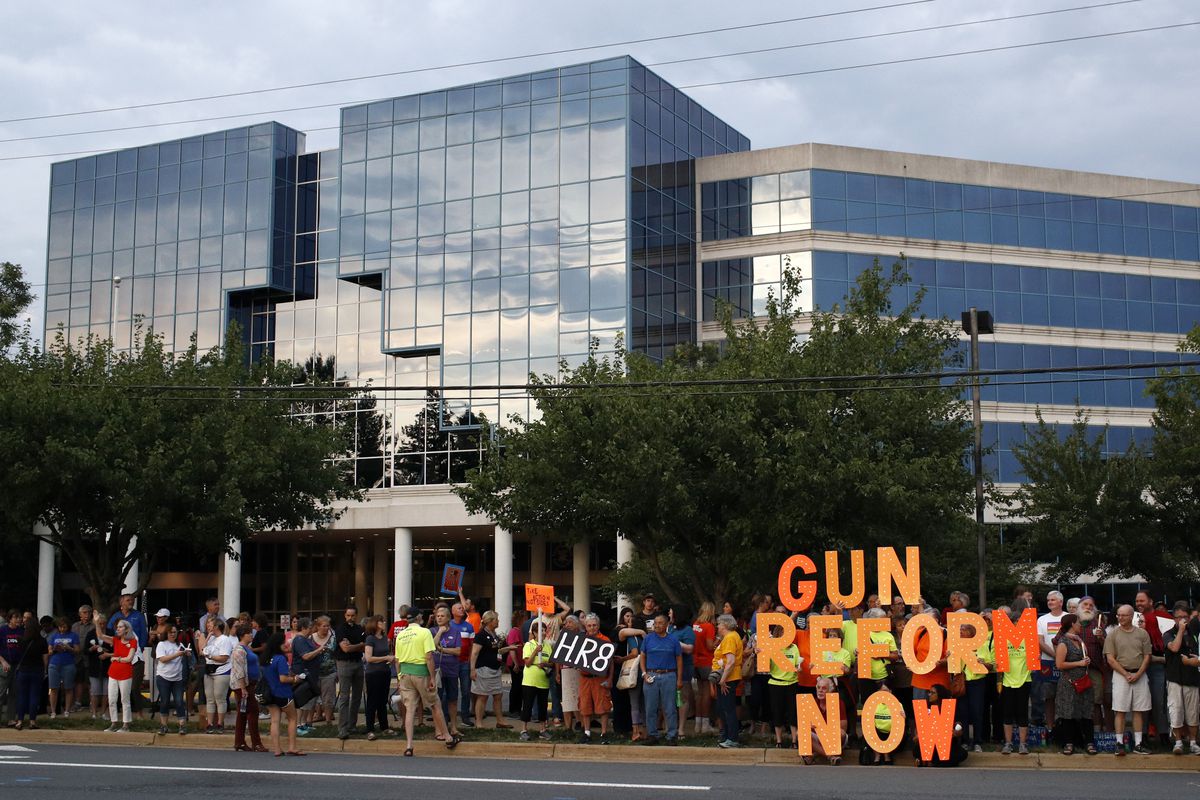 In this Aug. 5, 2019, file photo, people gather at a vigil for recent victims of gun violence outside the National Rifle Association’s headquarters building in Fairfax, Va.