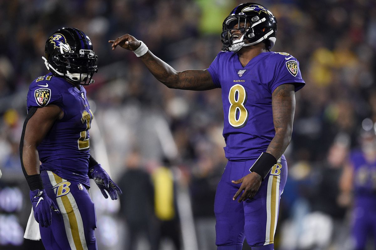 Baltimore Ravens quarterback Lamar Jackson celebrates with running back Mar...