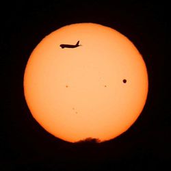 A jet crosses in front of the sun as Venus transits the sun, as seen from Kaysville, Tuesday, June 5, 2012.