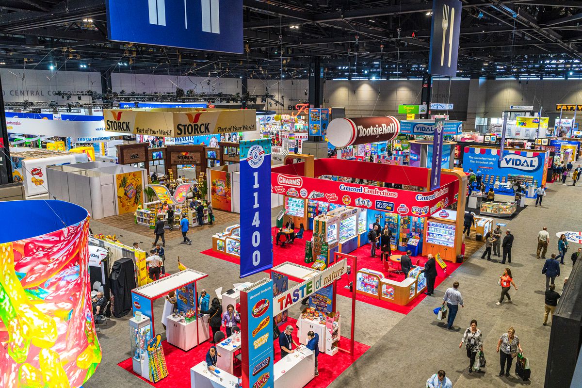 A large expo floor studded with colorful booths, many with large banners and ads.