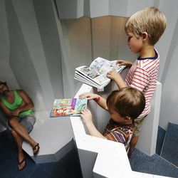 GK Risser watches his sons Van and Augie as they read at the Salt Lake Main Library in Salt Lake City Friday, Aug. 29, 2014.