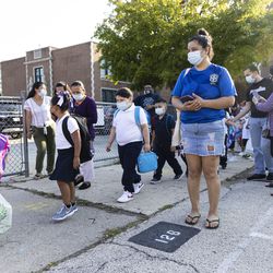 Students wait in line as they return to school on the first day of classes at Alessandro Volta Elementary School.