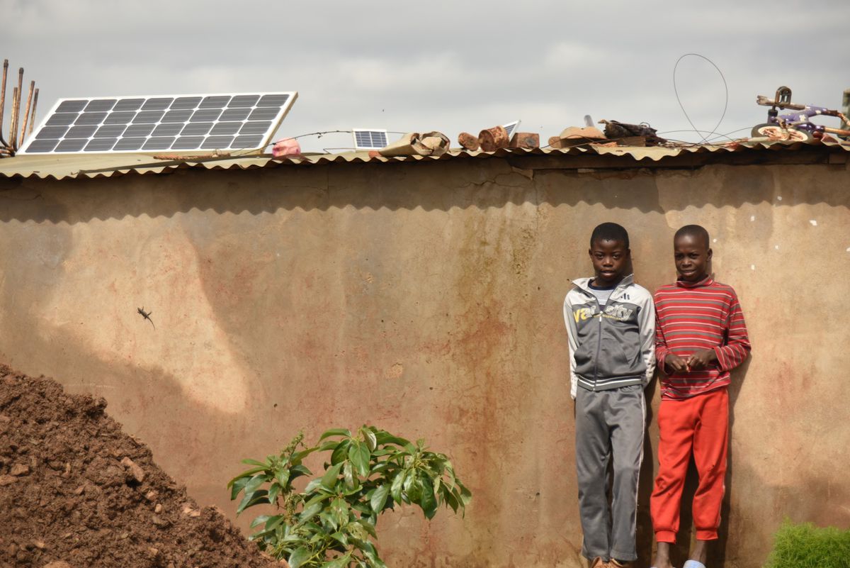  These two boys were hanging out when I walked by, and quickly chose a formal pose in front of their home, which has a large permanent solar panel mounted on the roof.