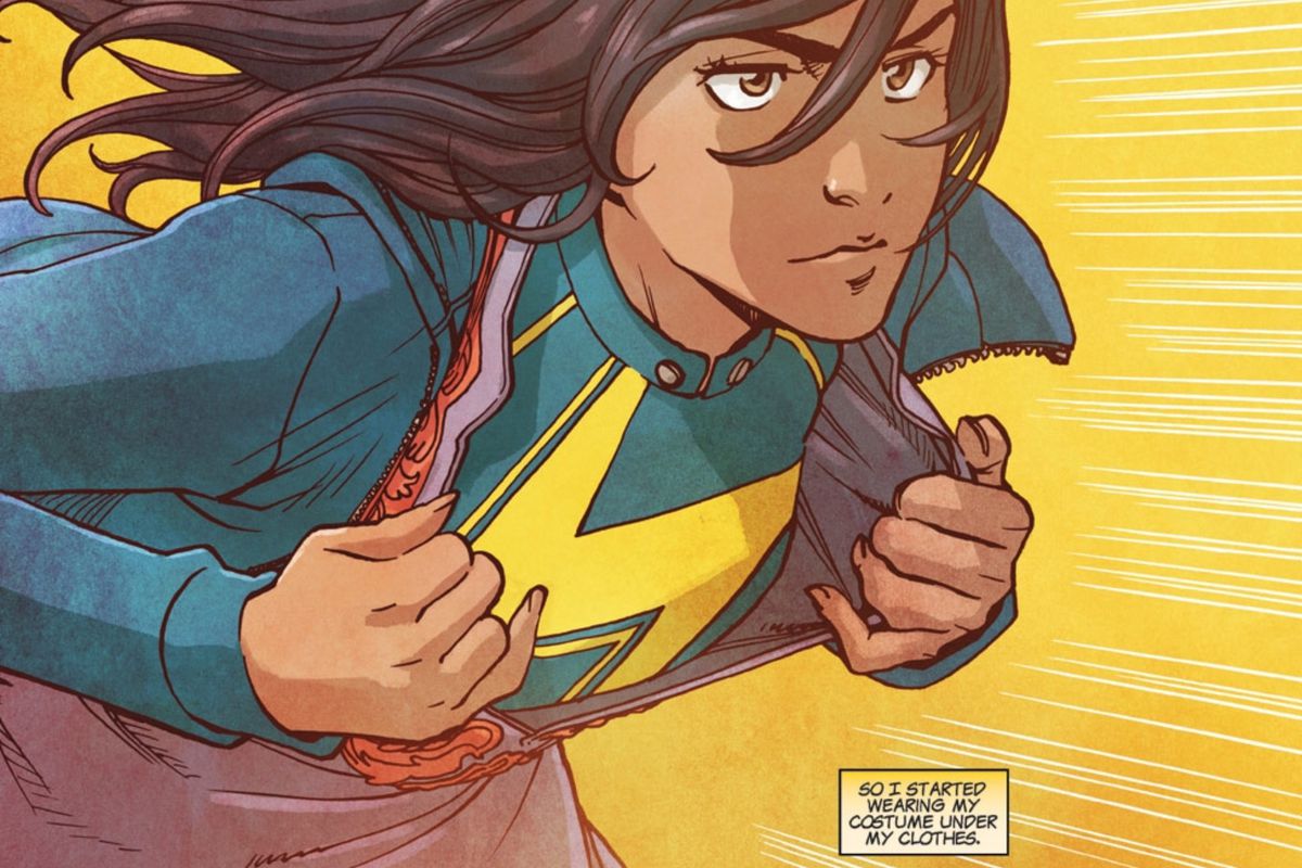Ms. Marvel, aka Kamala Khan, a Pakistani-American Muslim superhero from Jersey City, springs into action, pulling her every day clothing open to reveal the yellow lightning bold insignia of her costume, in Ms. Marvel #13, Marvel Comics (2015).
