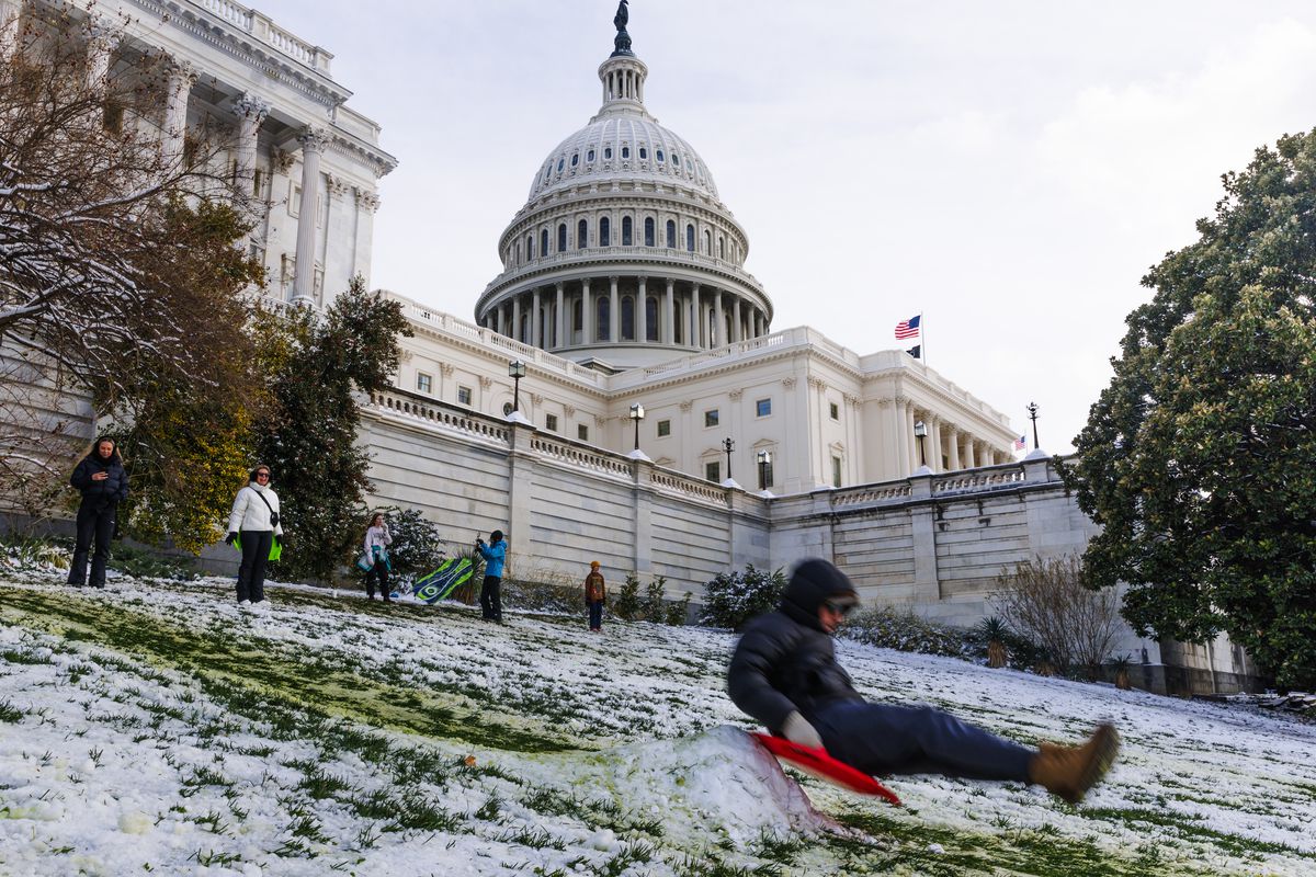 Children are sledding in front of the Capitol Building in Washington, DC, on January 16, after the region received 2-4 inches of snow, marking the first significant snowstorm in over two years for the city.