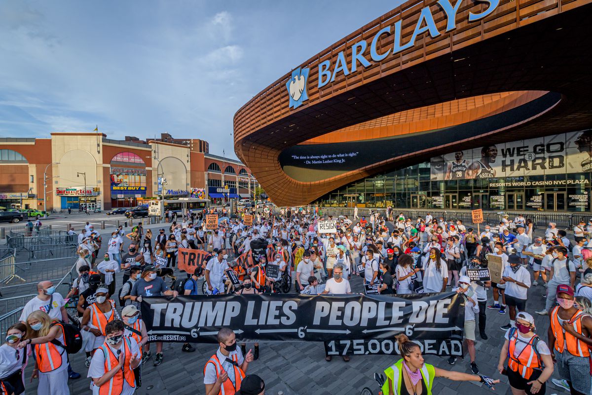 Participants taking the streets while holding a Trump Lies,...