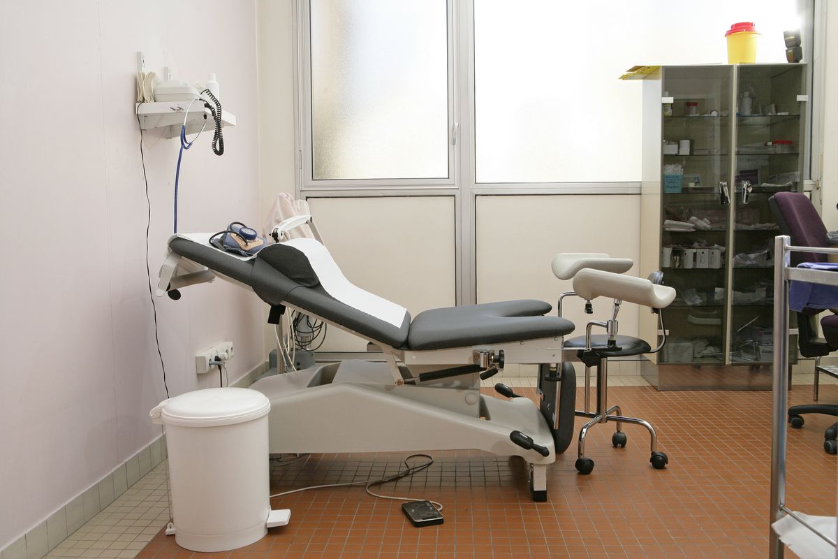 A gynecological exam room with long medical table.