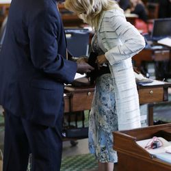 Sen. Rodney Ellis, D-Houston, left, helps Sen. Wendy Davis, D-Fort Worth, right, with a back brace during her filibusters of an abortion bill, Tuesday, June 25, 2013, in Austin, Texas. Davis was given a second warning for breaking filibuster rules. (AP Photo/Eric Gay)