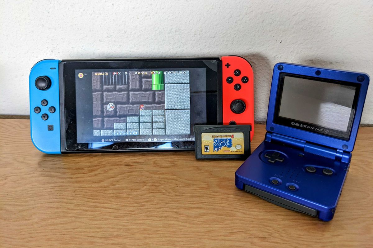 A Nintendo Switch with a screenshot of a Mario Bros. 3 dungeon level posed next to a Game Boy Advance SP. A Super Mario Bros. 3 GBA cartridge is propped up against the Switch.