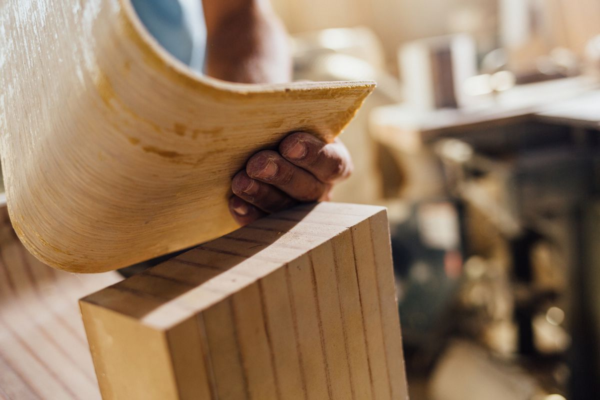 A piece of wood being bent by hand