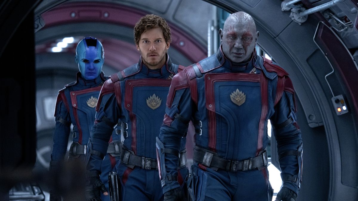 Star-Lord (Chris Pratt), Drax the Destroyer (Dave Bautista), and Nebula (Karen Gillan) walk through a ship hallway in uniform in Guardians of the Galaxy Vol. 3