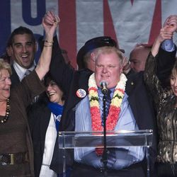 FILE - In this Oct. 25, 2010 file photo, Toronto Mayor-elect Rob Ford, center raises his arms with his wife Renata, right, and mother Diane, left, as he speaks to supporters in Toronto. Ford, whose career crashed in a drug-driven, obscenity-laced debacle, died Tuesday, March 22, 2016 after fighting cancer, his family says. He was 46.