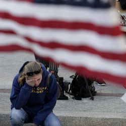 Jillian Blenis, 30, of Boston, reacts while stopping at a makeshift memorial, Wednesday, April 17, 2013, in Boston. The city continues to cope following Monday's explosions near the finish line of the Boston Marathon. 