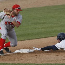 BYU's Adam Law slides safely into third as Utah's Biss Larsen tries to make the tag as Brigham Young University plays University of Utah in baseball Tuesday, April 23, 2013, in Provo.