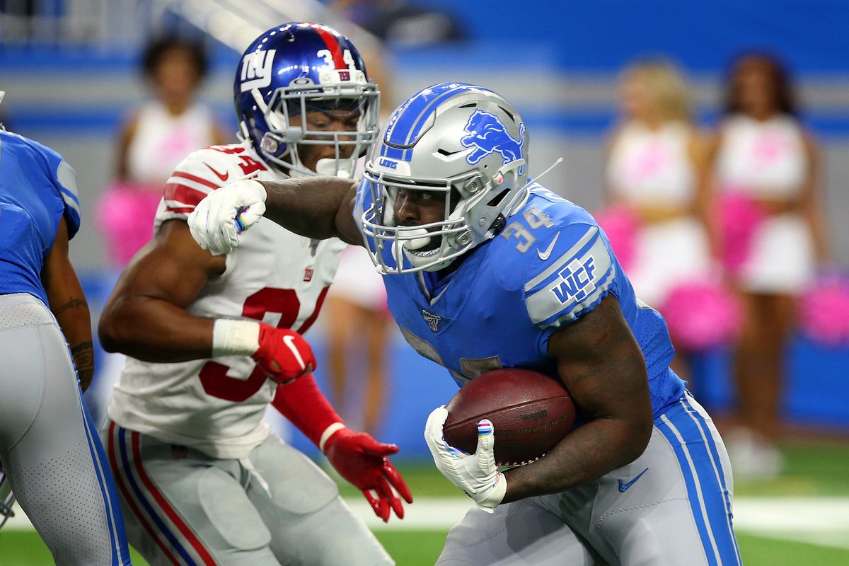 Detroit Lions running back Tra Carson carries the ball under the pressure of New York Giants defensive back Grant Haley during the second half of an NFL football game against the New York Giants in Detroit, Michigan USA, on Sunday, October 27, 2019.