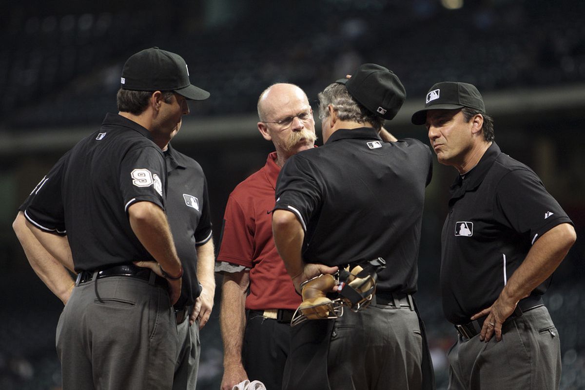HOUSTON - JUNE 09:  Houston Astros trainer Rex Jones (C) checks on home plate umpire Tom Hallion (2R) after being struck by a foul ball in the ninth inning at Minute Maid Park on June 9, 2011 in Houston, Texas.  (Photo by Bob Levey/Getty Images)