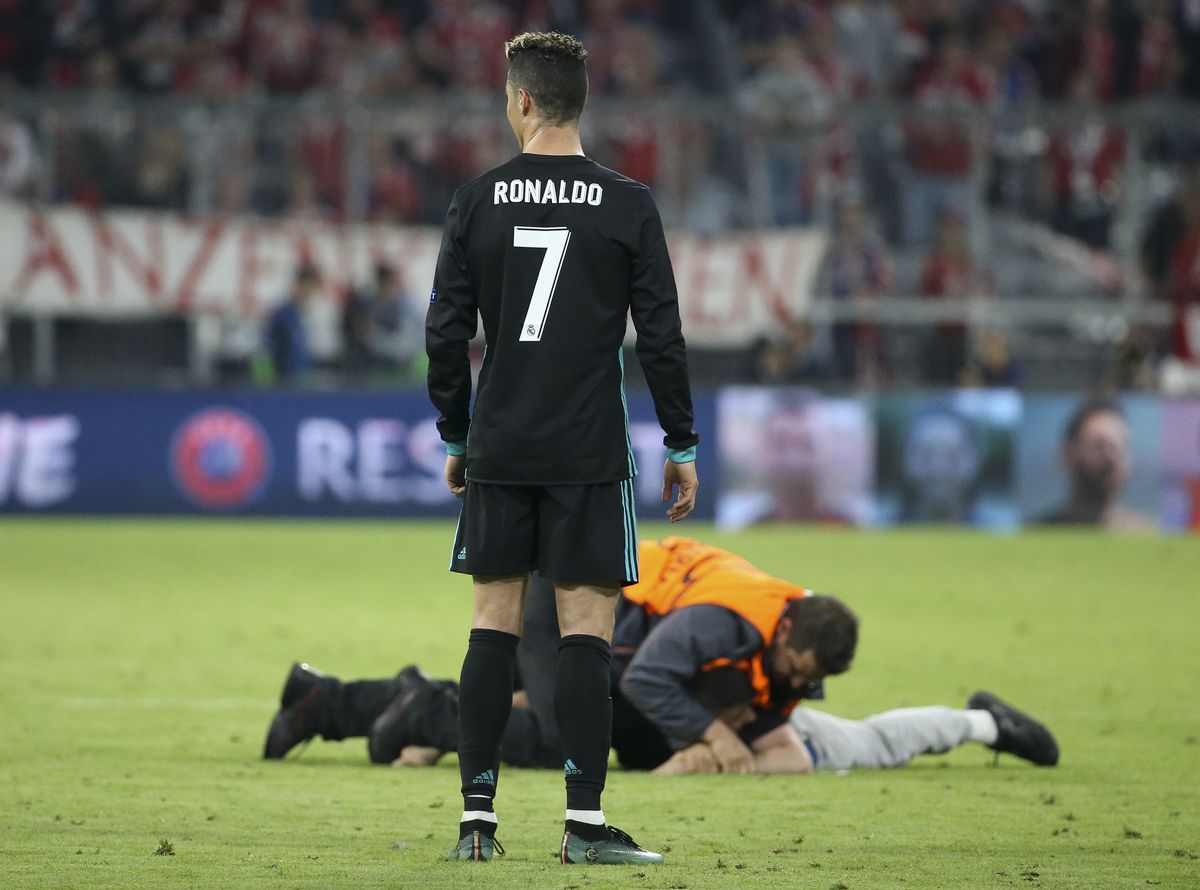 MUNICH, GERMANY - APRIL 25: Cristiano Ronaldo of Real Madrid watches a fan who wanted a selfie with him being tackled following the UEFA Champions League Semi Final first leg match between Bayern Muenchen (Bayern Munich) and Real Madrid at the Allianz Arena on April 25, 2018 in Munich, Germany.