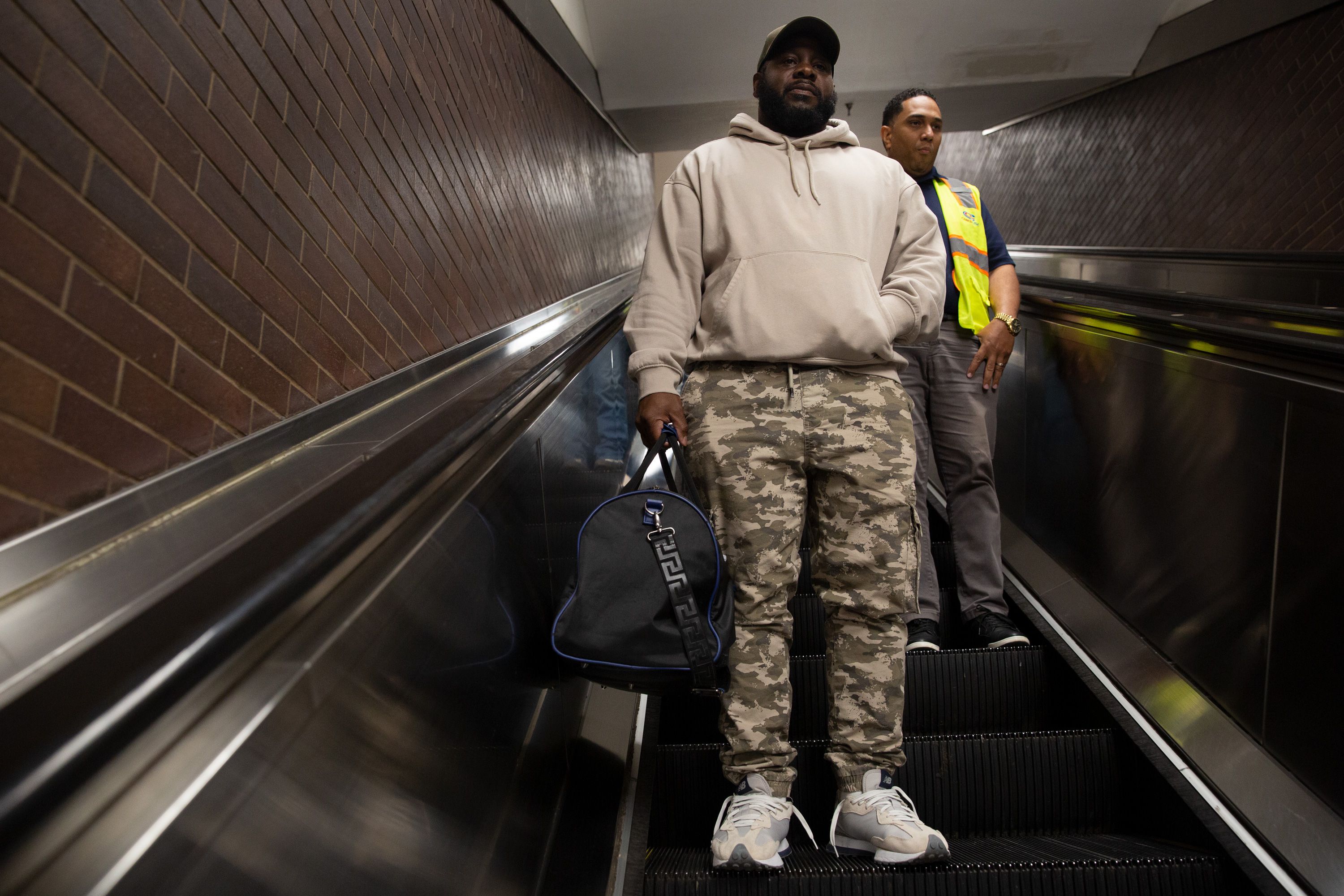 Carlos Jones carries a duffle bag down an escalator at Port Authority.