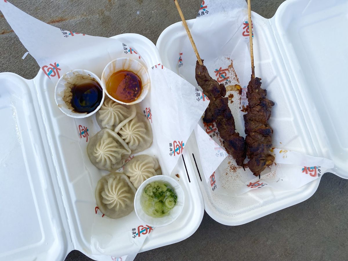 Dumplings and lamb skewers from Xiao Chi Jie in white trays.