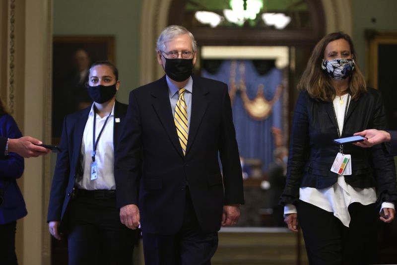 Mitch McConnell walking and wearing a mask.
