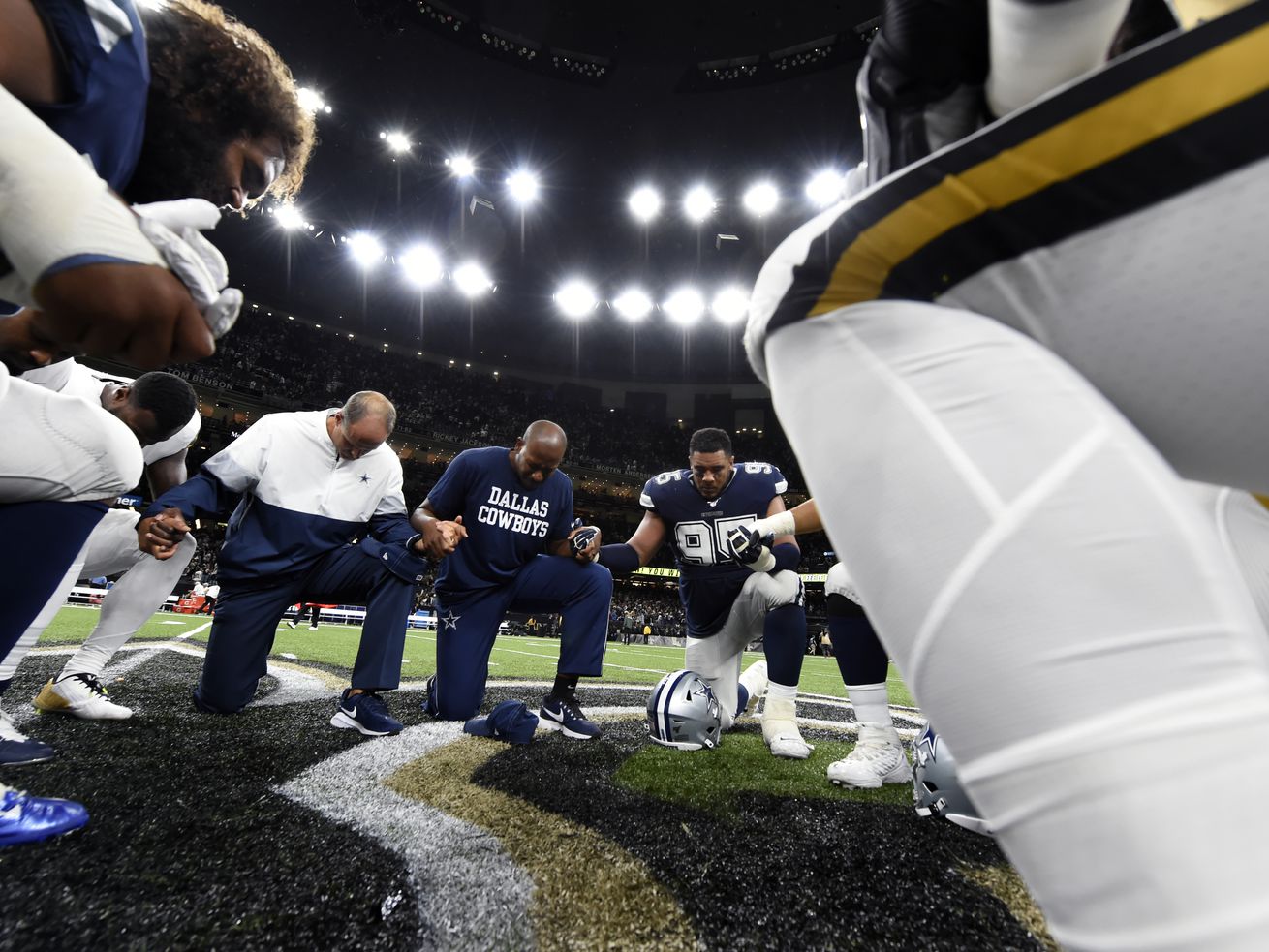 Players and coaches from the New Orleans Saints and Dallas Cowboys pray together on the field after a Sept. 2019 game.