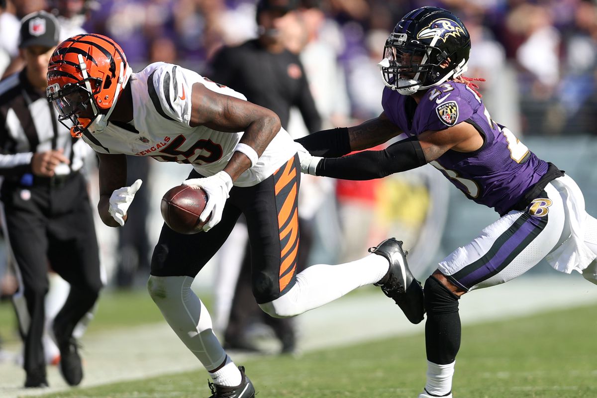 Tee Higgins #85 of the Cincinnati Bengals runs with the ball as Anthony Averett #23 of the Baltimore Ravens defends during the second half in the game at M&amp;T Bank Stadium on October 24, 2021 in Baltimore, Maryland.