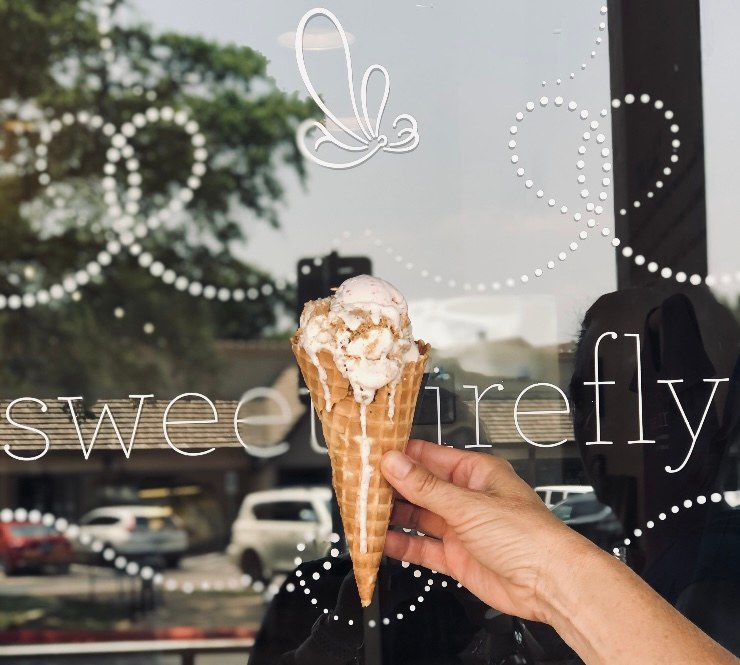 A woman’s hand holds a waffle cone of ice cream that is dripping down the sides.