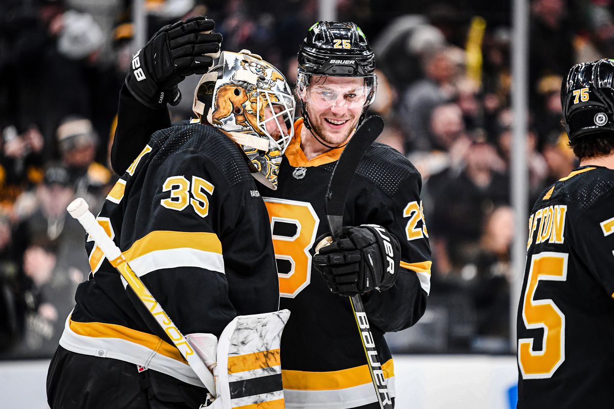 Brandon Carlo of the Boston Bruins celebrates a win against the Detroit Red Wings with Linus Ullmark at TD Garden on March 11, 2023 in Boston, Massachusetts.