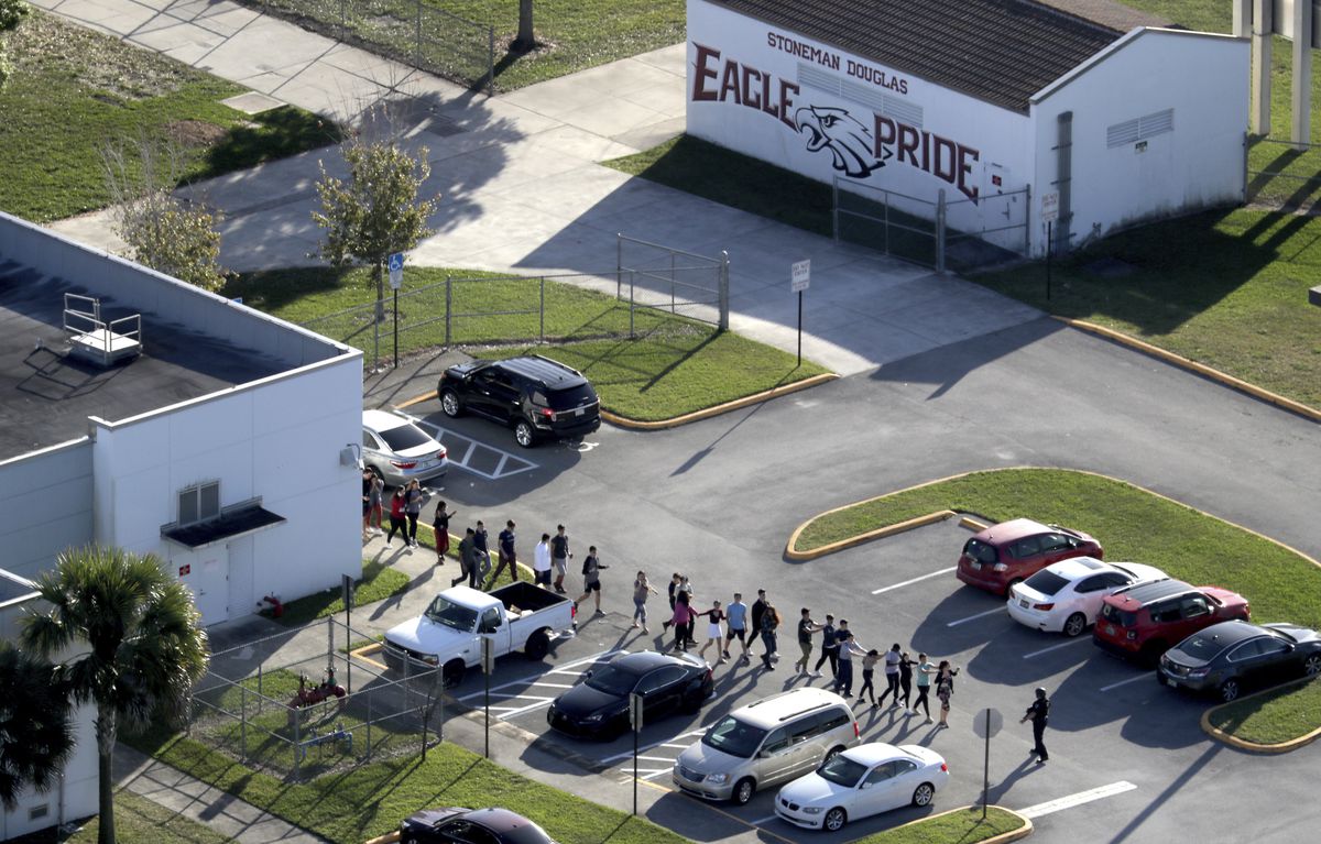 Students are evacuated by police from Marjorie Stoneman Douglas High School in Parkland, Fla., on Wednesday, Feb. 14, 2018, after a shooter opened fire on the campus. (Mike Stocker/South Florida Sun-Sentinel via AP)