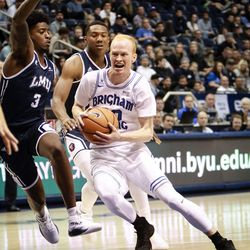 Brigham Young Cougars guard TJ Haws (30) drives the lane around Loyola Marymount Lions guard Cameron Allen (3) and guard Donald Gipson (2) as the Brigham Young Cougars take on the Loyola Marymount Lions at the Marriott Center in Provo on Thursday, Jan. 18, 2018.