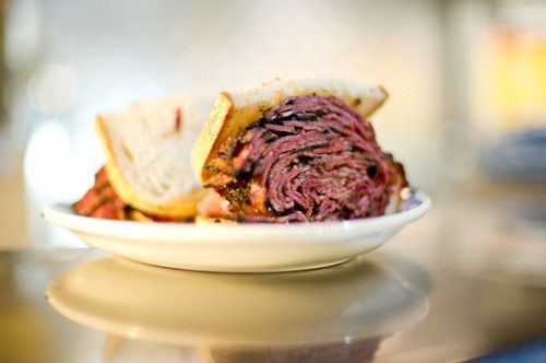 A pastrami sandwich on a white plate