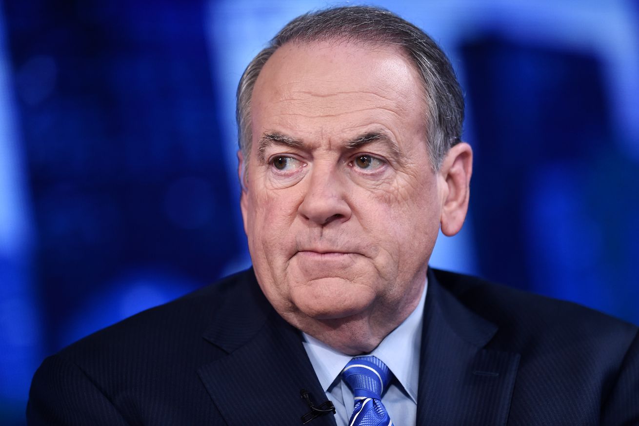 Mike Huckabee photographed from the shoulders up. He is wearing a suit and has a tense look on his face.