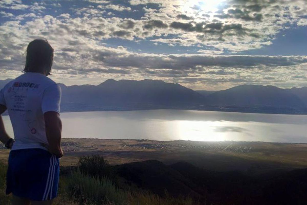 A runner looks over Utah Lake from the mountain above.