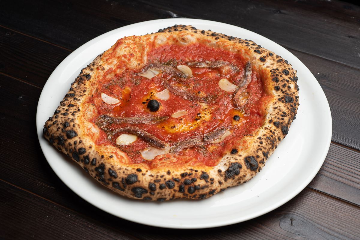 Marinara pizza with anchovies on a white plate at Ronan