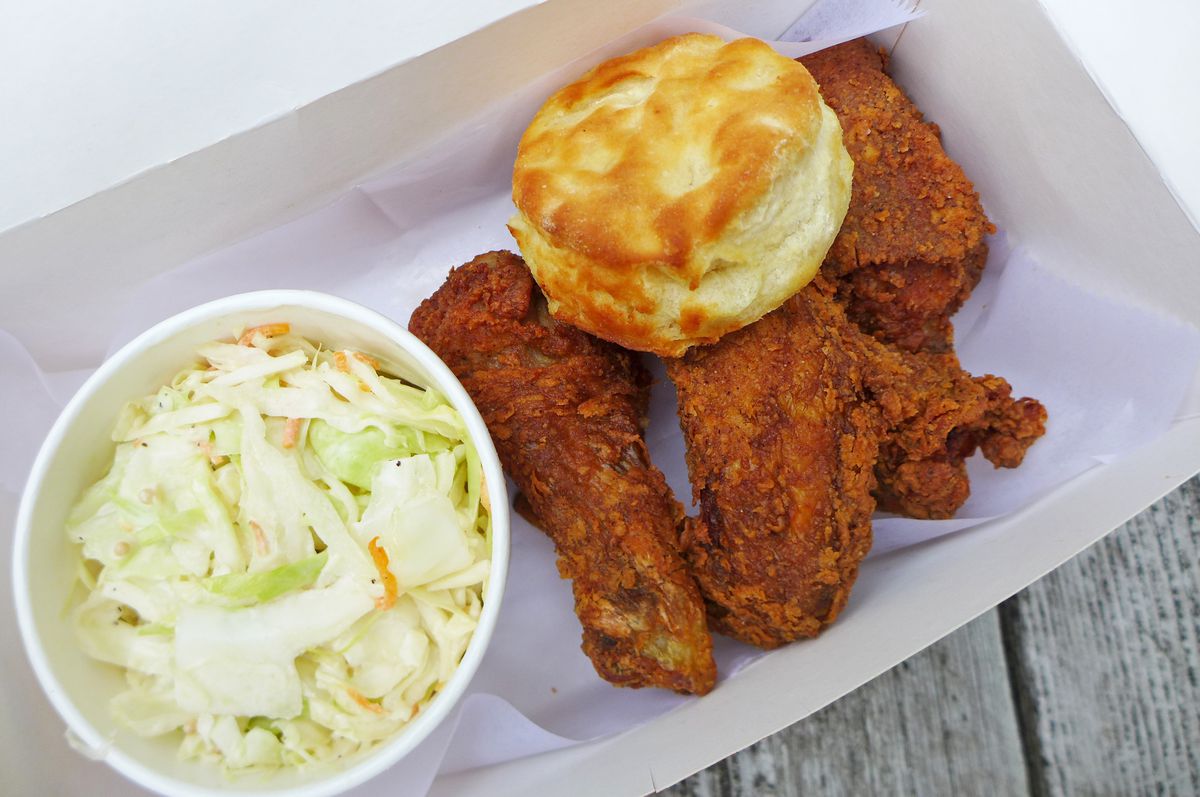 Fried chicken and a biscuit in a box with slaw on the side.
