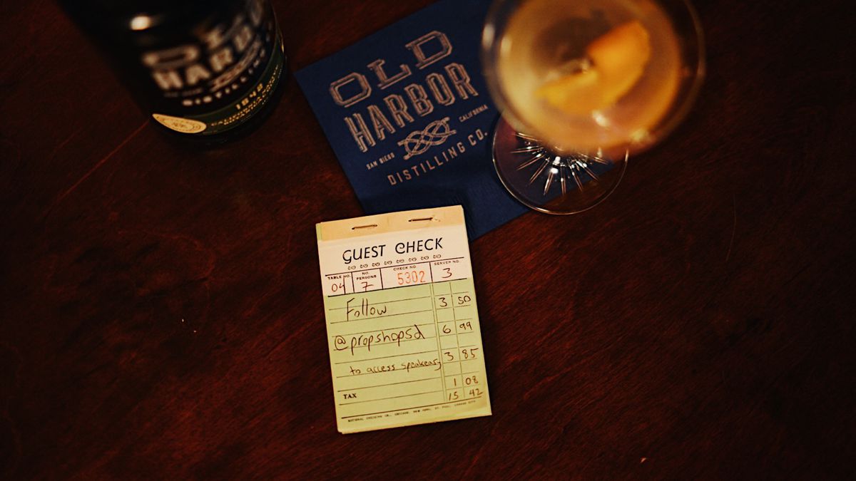 A receipt book with a cocktail on a bar.