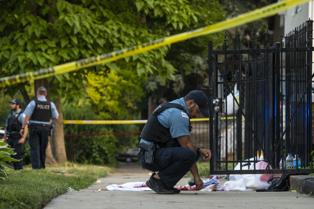Chicago police work the scene where three people were shot including one killed in the 5400 block of South Bishop St in the Back of the Yards neighborhood, Friday, June 18, 2021.