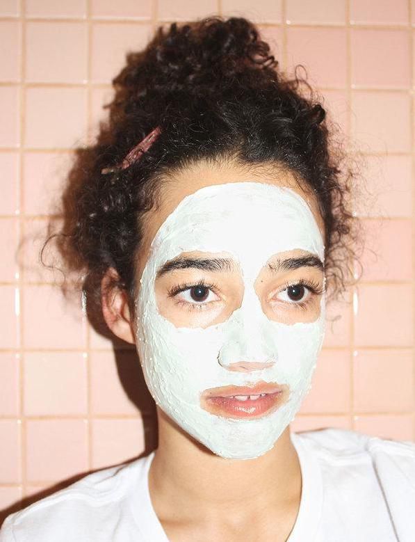 A woman wearing the Glossier Mega Greens face mask