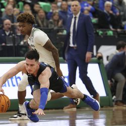 Brigham Young Cougars guard Alex Barcello (13) drives for a loose ball past Utah Valley Wolverines guard Justin Harmon (24) at Utah Valley University in Orem on Wednesday, Dec. 1, 2021.