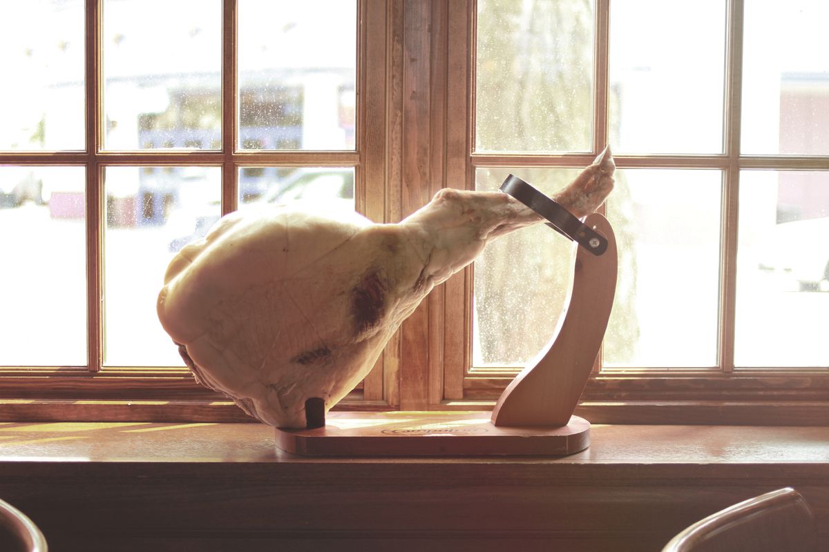 A pork shank in a holder on a window ledge.