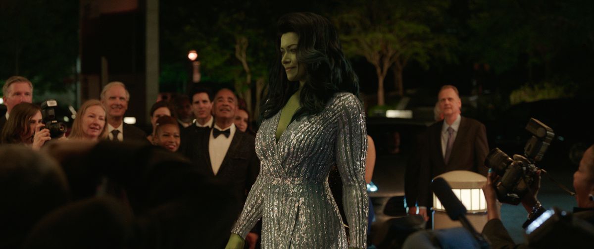 she-hulk walking to a crowd of fans, wearing a sparkling dress