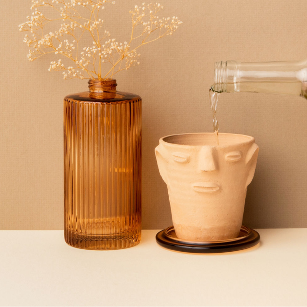 A ceramic cup with a face on it next to a bottle