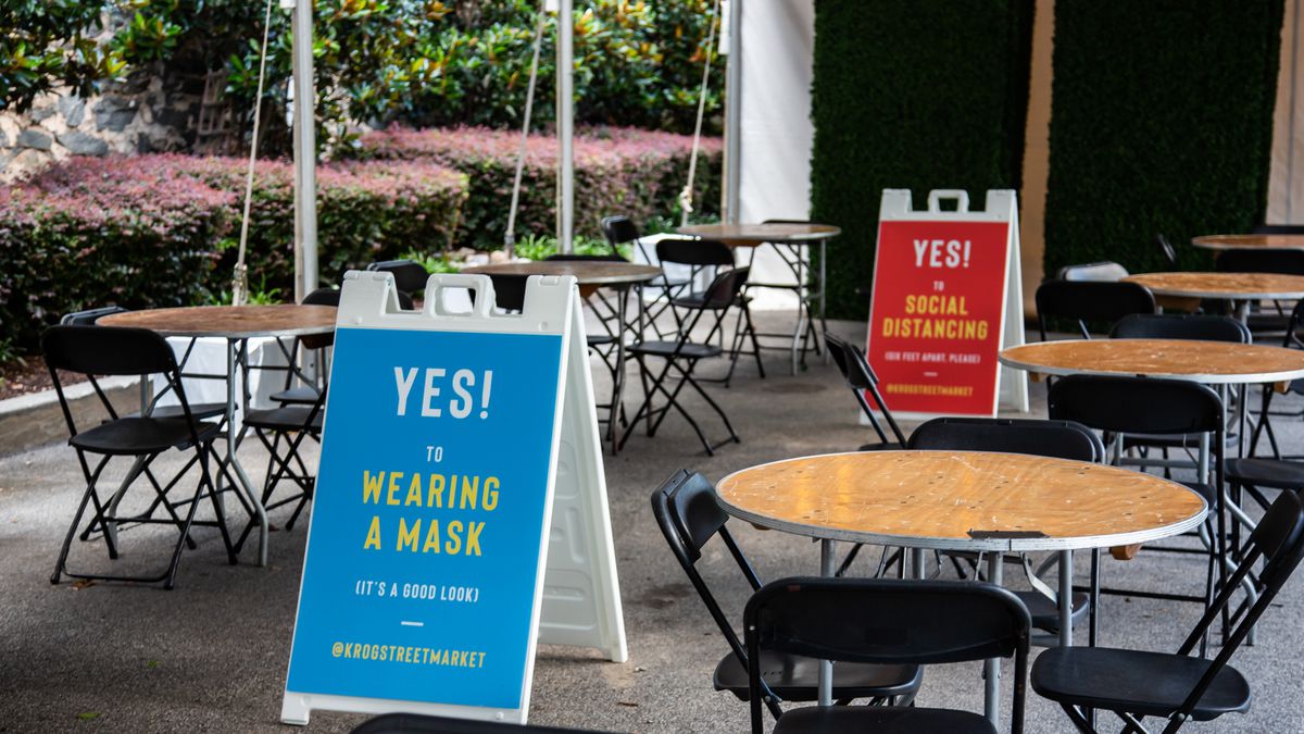 Signs posted on the patio at Krog Street Market in Inman Park encouraging people to wear masks