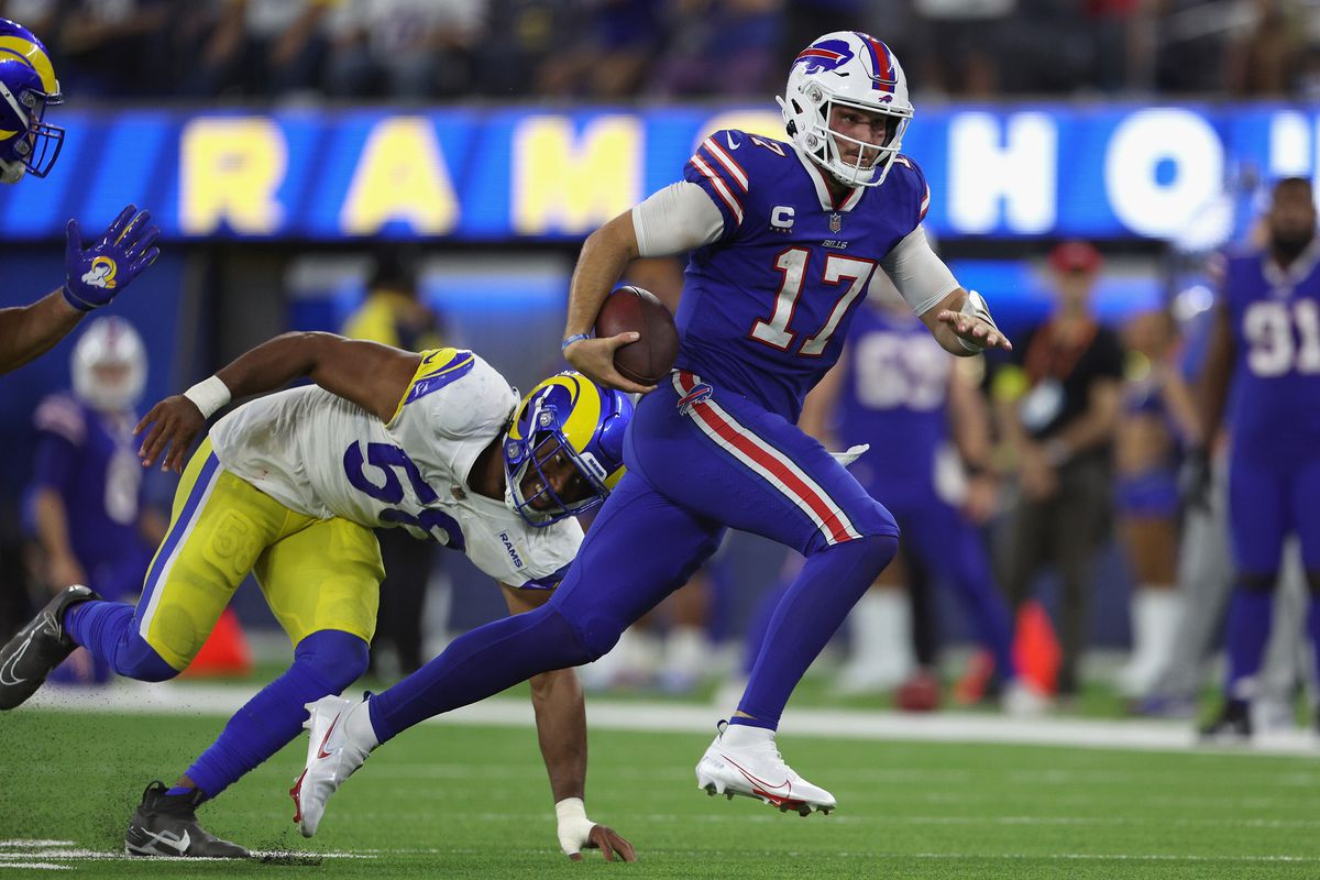 INGLEWOOD, CALIFORNIA - SEPTEMBER 08: Quarterback Josh Allen #17 of the Buffalo Bills scrambles with the football past linebacker Justin Hollins #58 of the Los Angeles Rams during the fourth quarter of the NFL game at SoFi Stadium on September 08, 2022 in Inglewood, California.