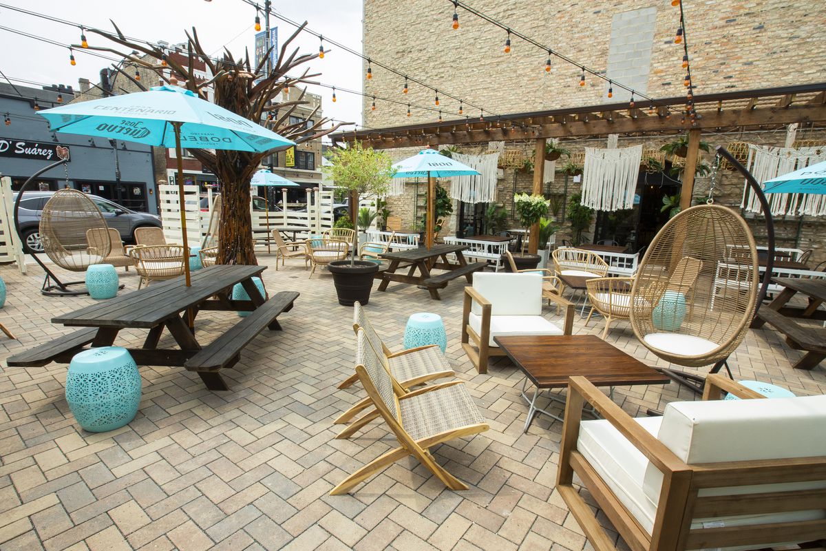 A large outdoor patio with wicker furniture and string lights.