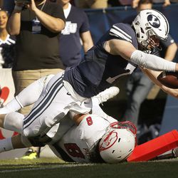 Brigham Young Cougars quarterback Taysom Hill (7) dives for a touchdwon over Southern Utah Thunderbirds defensive lineman Taylor Pili (8)  in Provo on Saturday, Nov. 12, 2016.