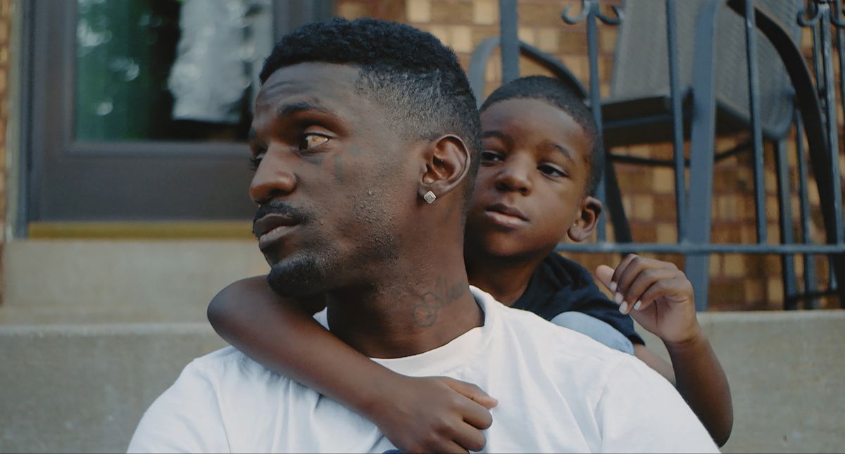 Bruce Franks Jr. with his son on his back, from the documentary St. Louis Superman