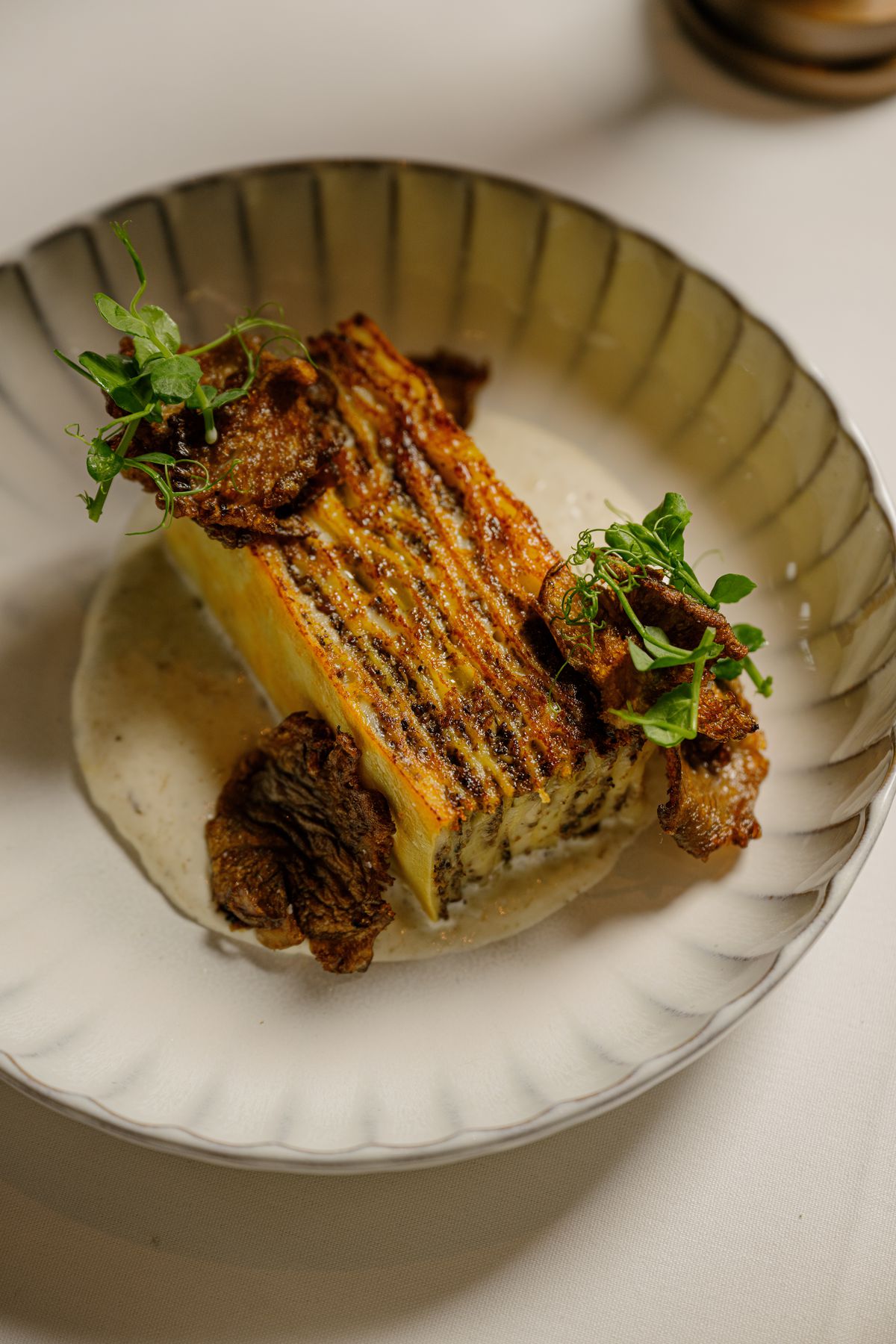 A wedge of lasagna on a plate. 