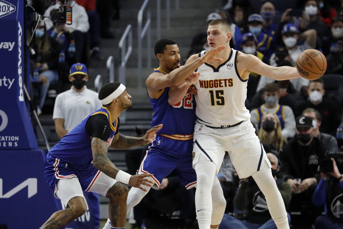 Denver Nuggets’ Nikola Jokic #15 holds the ball away as he’s double teamed by Golden State Warriors’ Otto Porter Jr. #32 and Gary Payton II #0 in the second quarter of their NBA game at the Chase Center in San Francisco, Calif., on Tuesday, Dec. 28, 2021.