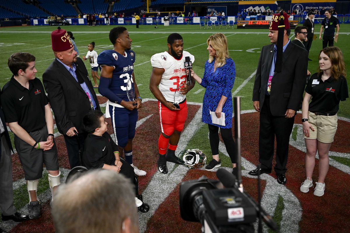 Team East running back Benny LeMay (32) and Team West safety Luther Kirk (34) receive the trophy for defensive and offensive most valuable player respectively in the 95th East-West Shrine Bowl at Tropicana Field.&nbsp;